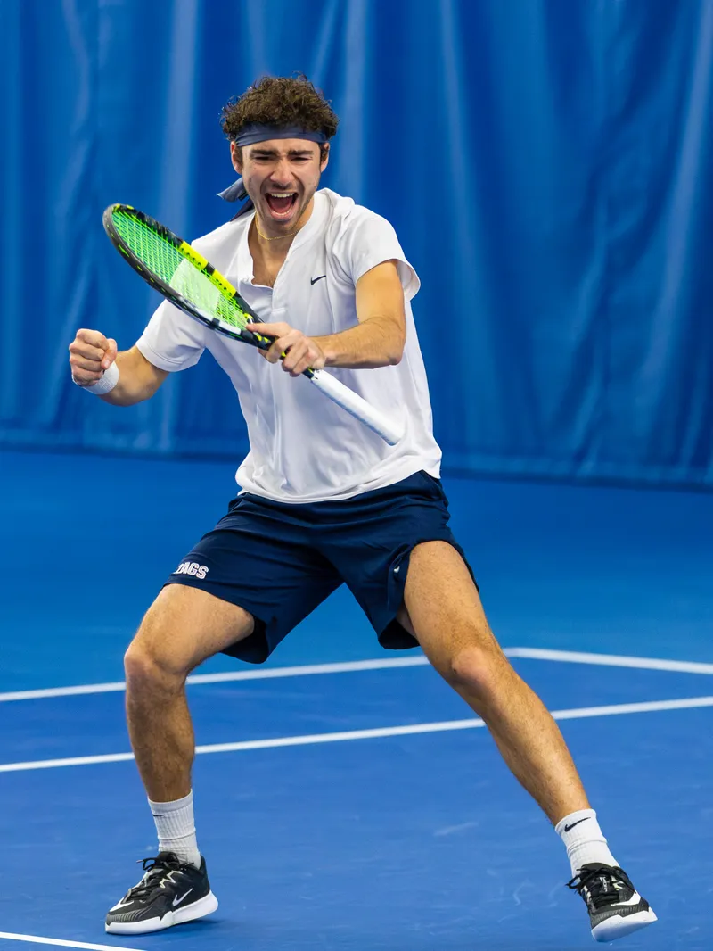 Oscar celebrating a win for Gonzaga, fist clenched, racket in hand